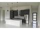 Modern kitchen boasts gray cabinets, stainless appliances, and a central island under elegant pendant lighting at 267 Santa Marta St, Port Charlotte, FL 33954