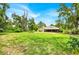 Lush backyard with a view of the home's exterior, featuring a screened-in patio at 2900 Hammock Dr, Plant City, FL 33566