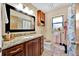 Updated bathroom features granite countertop vanity, framed mirror, wood cabinets and shower with butterfly curtain at 2900 Hammock Dr, Plant City, FL 33566