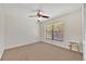 Neutral bedroom with carpet flooring features a ceiling fan, bright window and a small modern table at 2900 Hammock Dr, Plant City, FL 33566