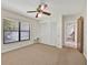 Bedroom with carpet, ceiling fan, large window, and closet; access to another room and white base trim at 2900 Hammock Dr, Plant City, FL 33566