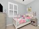 Bright bedroom featuring a window, light wood floor, and playful decor at 8410 Red Spruce Ave, Riverview, FL 33578