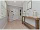 Welcoming foyer with light wood floors, console table, and gray walls with white trim at 8410 Red Spruce Ave, Riverview, FL 33578