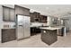 Bright kitchen with stainless steel appliances, dark cabinets, and an island with a countertop at 8410 Red Spruce Ave, Riverview, FL 33578