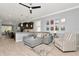 Living room boasts a plush gray sectional, ceiling fan, and decoratively adorned walls at 8410 Red Spruce Ave, Riverview, FL 33578