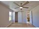 Modern bedroom with a ceiling fan, barn door closet, and an open doorway to a bathroom at 1933 Oregon Trl, Englewood, FL 34224