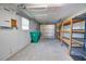 Spacious garage with storage shelving, peg board, and an easy-access roll-up door at 1933 Oregon Trl, Englewood, FL 34224