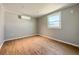 An empty bedroom featuring light wood flooring, a modern window, and a sleek air conditioner at 5141 Oakland Hills Ave, Sarasota, FL 34234