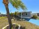 Charming home with a well-manicured lawn, landscaping, and a blue patio perfect for enjoying the outdoors at 5141 Oakland Hills Ave, Sarasota, FL 34234