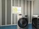 A modern laundry room with a front load washer and dryer set at 5141 Oakland Hills Ave, Sarasota, FL 34234