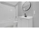 Cozy bathroom featuring a round mirror, white tiled shower/tub, and a white vanity at 7511 Savannah Ln, Tampa, FL 33637