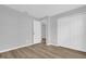 Neutral bedroom featuring wood-look floors, white trim, and a double door closet for ample storage at 7511 Savannah Ln, Tampa, FL 33637