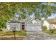 Charming single-story home with a well-manicured lawn, mature trees, and a two-car garage at 7511 Savannah Ln, Tampa, FL 33637