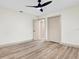 Bedroom with wood laminate floors, ceiling fan, light neutral paint and a double-door closet at 203 Driftwood W Dr, Palm Harbor, FL 34683