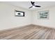 An airy room with neutral tones features wood laminate flooring and a modern black ceiling fan with a light at 203 Driftwood W Dr, Palm Harbor, FL 34683