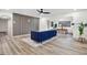 Stylish living room featuring wood floors, a modern blue sofa, and seamless access to the dining area at 203 Driftwood W Dr, Palm Harbor, FL 34683