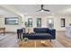 Bright living room with natural light, a stylish blue sofa, and wood-look floors for a cozy feel at 203 Driftwood W Dr, Palm Harbor, FL 34683