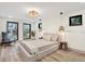 Serene main bedroom with neutral tones, modern light fixtures, and large windows that provide natural light at 203 Driftwood W Dr, Palm Harbor, FL 34683