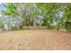 A large backyard with mature trees, a wooden fence, and ample space for outdoor activities at 3944 11Th S Ave, St Petersburg, FL 33711