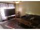 Inviting living room with a comfy sofa, rug, and a large TV at 6718 Runningwoods Dr, Tampa, FL 33634
