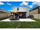Spacious backyard featuring a dining area and outdoor kitchen beneath a pergola at 9188 Forge Breeze Loop, Wesley Chapel, FL 33545