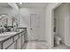 Bright bathroom with double sink vanity, granite countertop, and separate toilet room at 9188 Forge Breeze Loop, Wesley Chapel, FL 33545