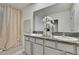 Well lit bathroom showcasing granite double vanity and curtained shower at 9188 Forge Breeze Loop, Wesley Chapel, FL 33545