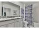 Stylish bathroom featuring double vanity, granite countertop, and tub with shower curtain at 9188 Forge Breeze Loop, Wesley Chapel, FL 33545