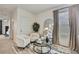Bright bedroom with two chairs, round table, decorative mirror, and neutral accents at 9188 Forge Breeze Loop, Wesley Chapel, FL 33545