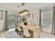 Elegant dining room featuring a chandelier, large window, and sliding door access to backyard at 9188 Forge Breeze Loop, Wesley Chapel, FL 33545