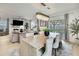 Open-concept living space with dining area featuring elegant chandelier and access to patio at 9188 Forge Breeze Loop, Wesley Chapel, FL 33545
