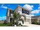Two-story home featuring beautiful landscaping, a two car garage and a beautiful blue sky at 9188 Forge Breeze Loop, Wesley Chapel, FL 33545