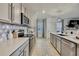 Bright kitchen with stainless appliances, white countertops and cabinets, open to living area at 9188 Forge Breeze Loop, Wesley Chapel, FL 33545