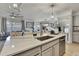 Well-lit kitchen with modern features and an island connecting to the living room at 9188 Forge Breeze Loop, Wesley Chapel, FL 33545
