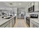 Modern kitchen with stainless steel appliances, grey cabinetry, and a backsplash at 9188 Forge Breeze Loop, Wesley Chapel, FL 33545