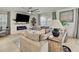 Bright living room featuring a modern fireplace, large sectional, and a ceiling fan at 9188 Forge Breeze Loop, Wesley Chapel, FL 33545