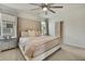 Elegant main bedroom with tufted headboard, plush bedding, and ensuite bathroom at 9188 Forge Breeze Loop, Wesley Chapel, FL 33545