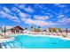 Resort-style pool area with lounge chairs, umbrellas, poolside bar, and clear blue sky at 9188 Forge Breeze Loop, Wesley Chapel, FL 33545