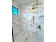 Elegant bathroom with marble tile, a modern shower system, and a window for natural light at 2309 S Ardson Pl # 1, Tampa, FL 33629