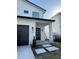 Modern two-story home featuring a black garage door and stylish exterior lighting at 2309 S Ardson Pl # 1, Tampa, FL 33629