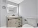 Updated bathroom vanity with modern lighting and stylish barn door detail at 4928 Stolls Ave, Tampa, FL 33615