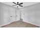 Bedroom with new flooring, neutral walls, a ceiling fan, and multiple access doors at 4928 Stolls Ave, Tampa, FL 33615