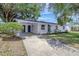 Bright exterior view of a single-Gathering home with a covered carport and well-kept front lawn at 4928 Stolls Ave, Tampa, FL 33615