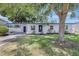 Charming single-story home featuring a well-manicured lawn and beautiful landscaping at 4928 Stolls Ave, Tampa, FL 33615