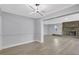 Open-concept living room showcasing a fireplace, light gray walls, new flooring, and a modern light fixture at 4928 Stolls Ave, Tampa, FL 33615