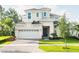 A charming, two-story home with a manicured lawn, brick driveway, and a two-car garage at 1031 Signet, Apollo Beach, FL 33572