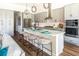 Modern kitchen featuring gray cabinets, granite countertops, an island with seating, and stainless steel appliances at 1031 Signet, Apollo Beach, FL 33572