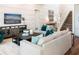Cozy living room with a plush sofa, coffee table, TV, and staircase leading to the second floor at 1031 Signet, Apollo Beach, FL 33572