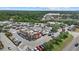Aerial view of the neighborhood featuring a restaurant, stores, parking lots, and surrounded by lush trees and greenery at 2682 Edwin Ave, North Port, FL 34288