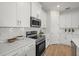 Close up on modern kitchen with stainless steel appliances, sleek white counter tops and lots of storage at 2682 Edwin Ave, North Port, FL 34288